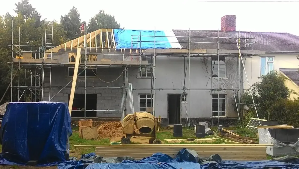 Two-storey extension under construction with a hipped roof timber structure by Heritage Joiners