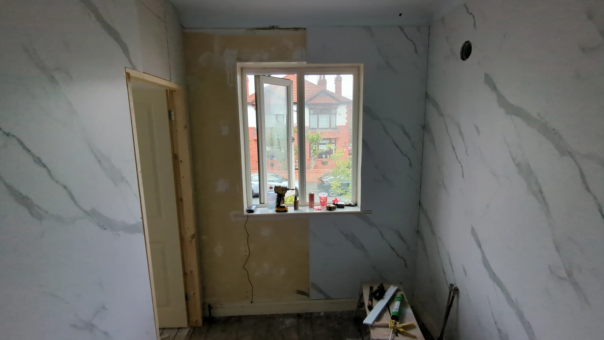 Bathroom wall panels fitted either side of the window while the window wall is still bare
