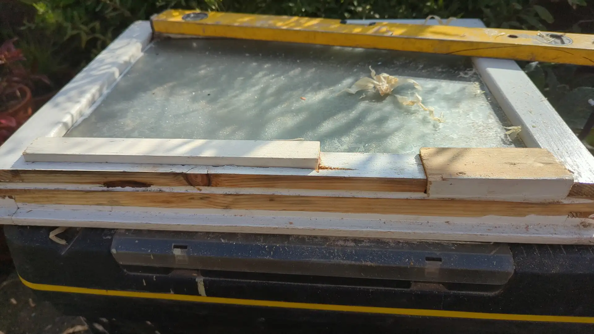 Casement window laid flat with new timber in the bottom rail and the original leaded glazing still in place