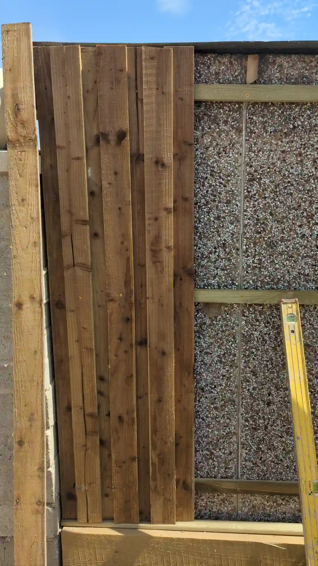First vertical timber cladding boards fixed to the battens and checked plumb