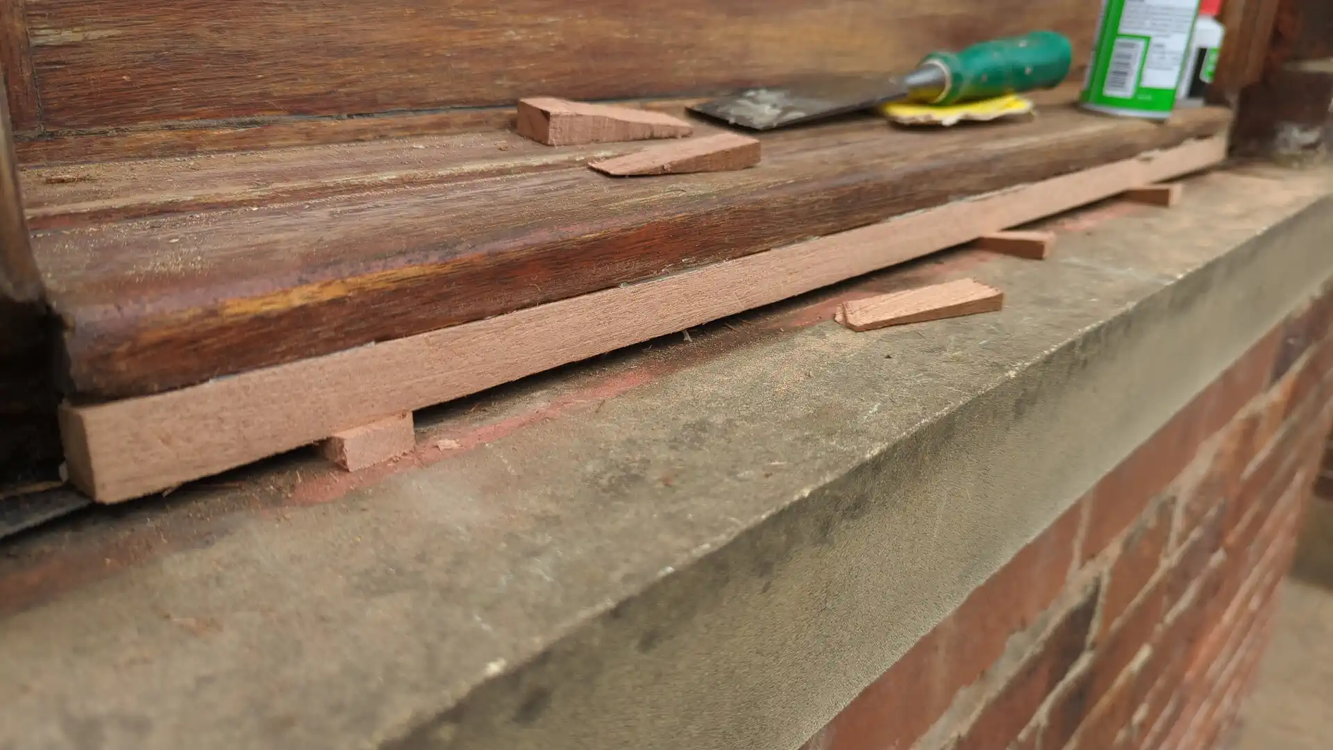 New sapele pieces shaped and dry-fitted along the bottom of a timber window sill