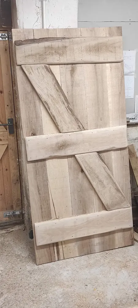 Solid oak ledged and braced door with live-edge plank, made in the workshop for The Counting House