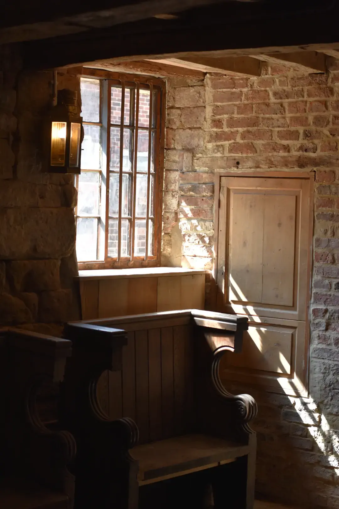 Timber boxing-in and panelling beneath a window in a period interior