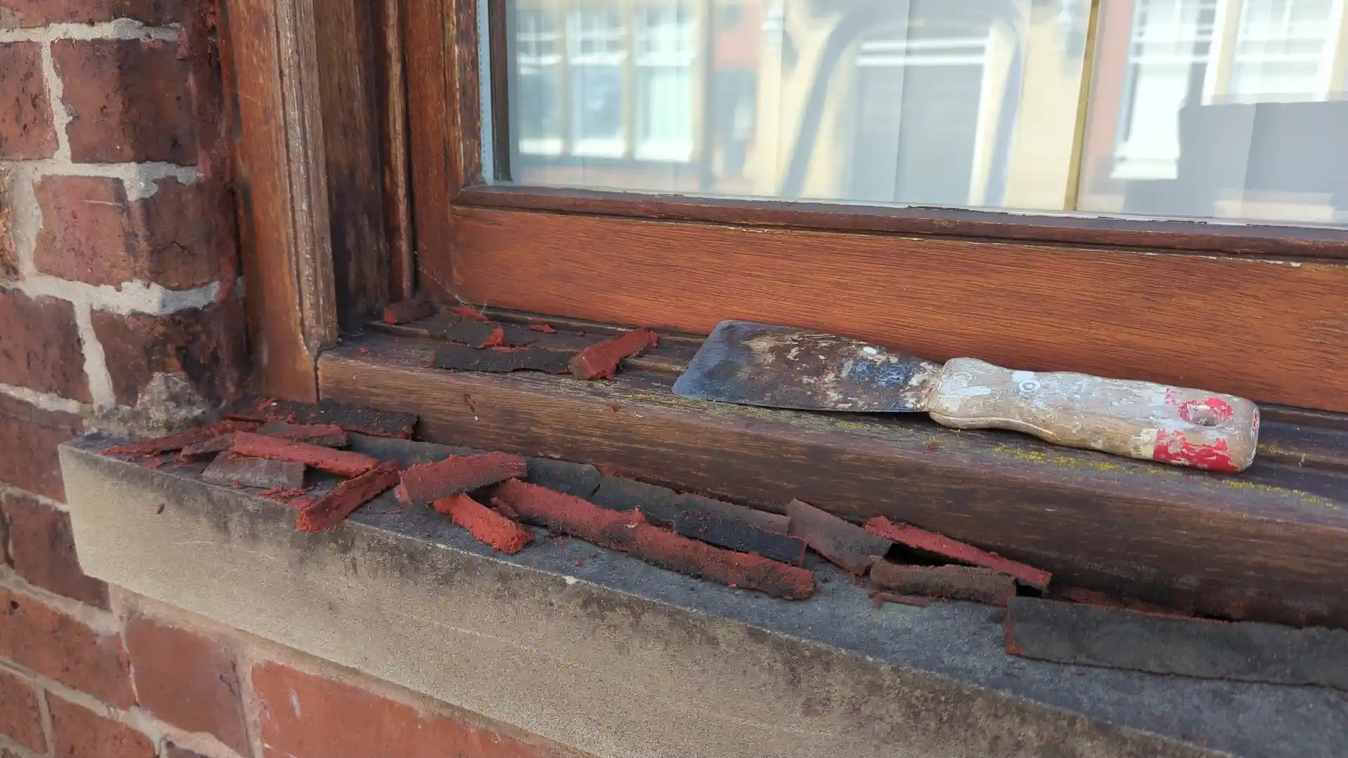 Failed perimeter sealant cut out of a sound timber window frame, ready to be renewed with the window retained