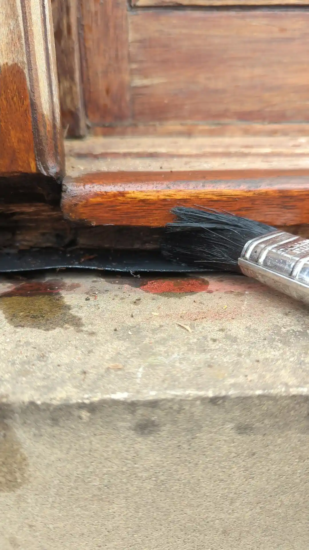 Wood preserver brushed into the bare bottom corner of a timber window frame before filling and coating