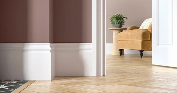 White skirting board and door architrave meeting in a decorated room